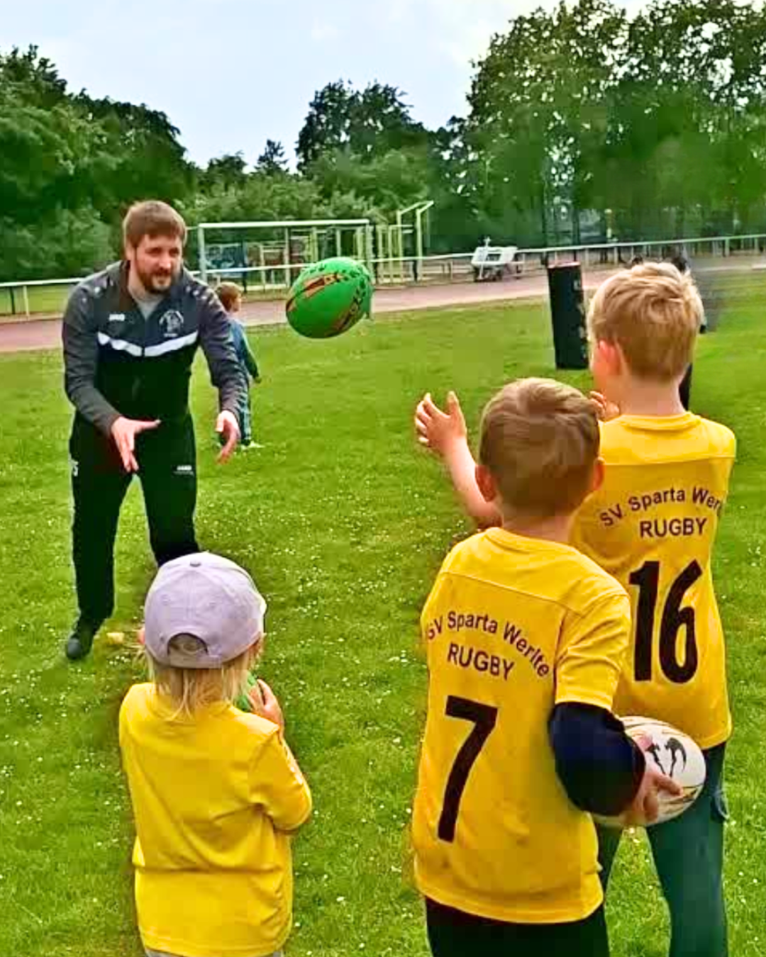 Florian übt mit den Kindern das Passen des Rugbyballs