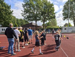 Kinder und Erwachsene beim Sommerfest von Rugby Werlte auf dem Sportplatz Brökersfehn