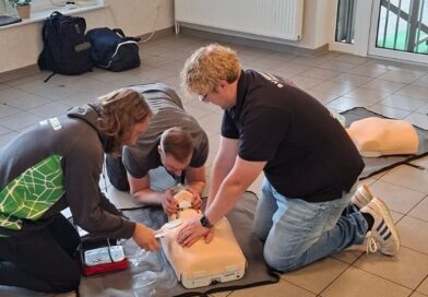 Teilnehmende üben Erste Hilfe an einer Reanimationspuppe beim Rugby-Kurs in Karlshöfen